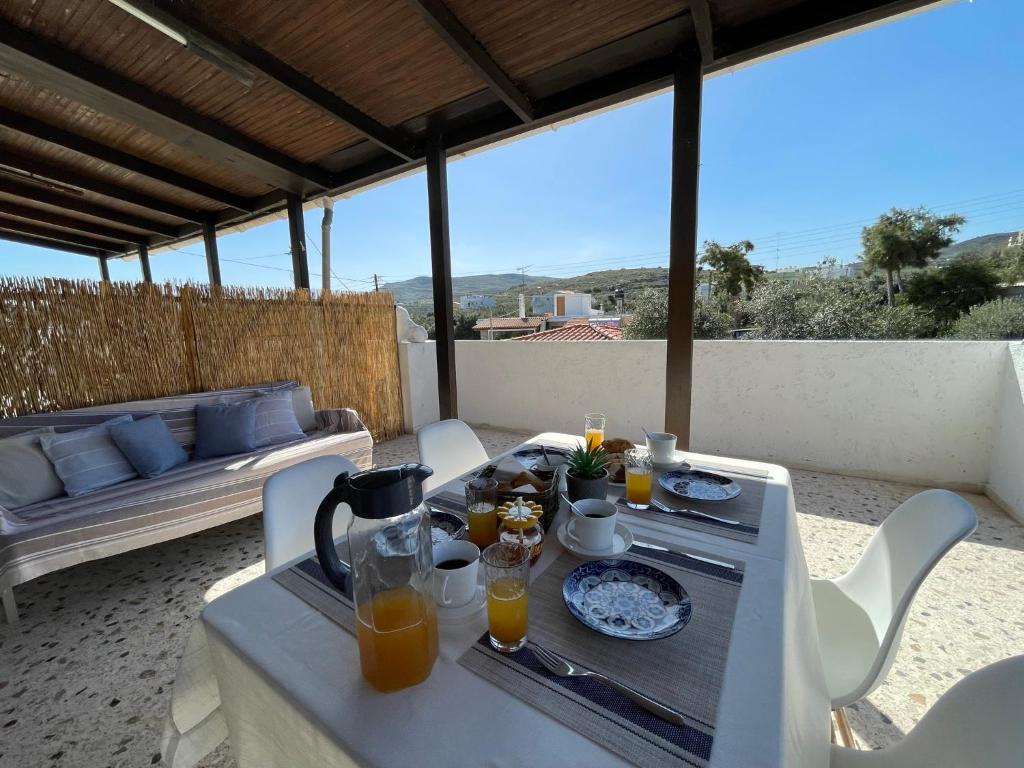 - une table avec de la nourriture et du jus d'orange sur une terrasse dans l'établissement Fyrogenis Cozy Family Friendly House in Gournes, à Gournes