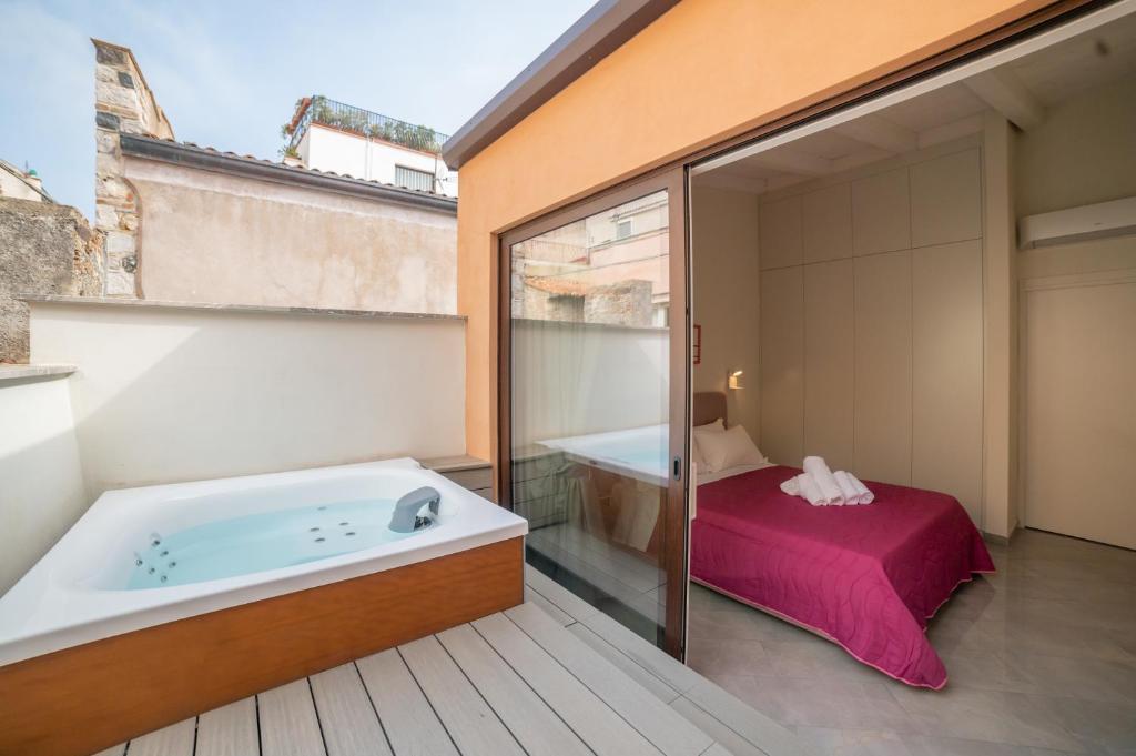 a bathroom with a tub and a bedroom with a bed at Casa Umberto I , Taormina Centro in Taormina