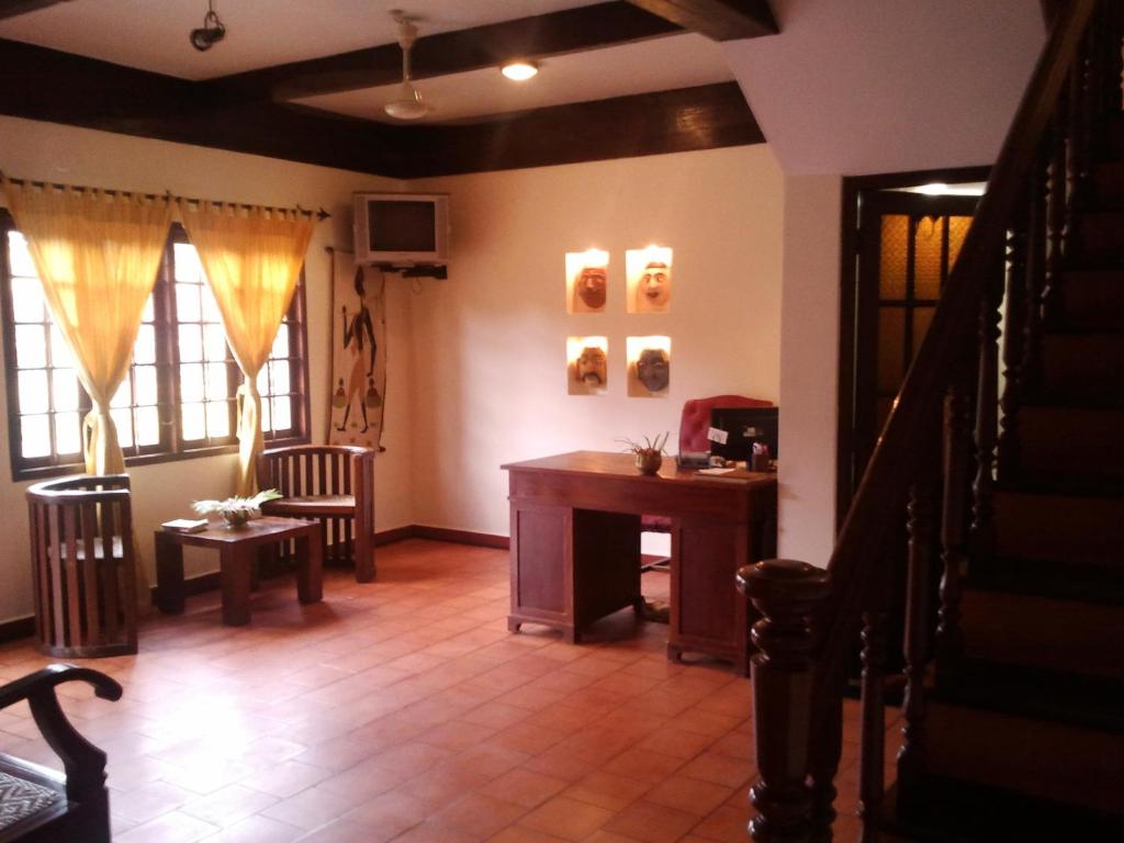 sala de estar con mesa y algunas ventanas en Raintree Lodge, en Kochi