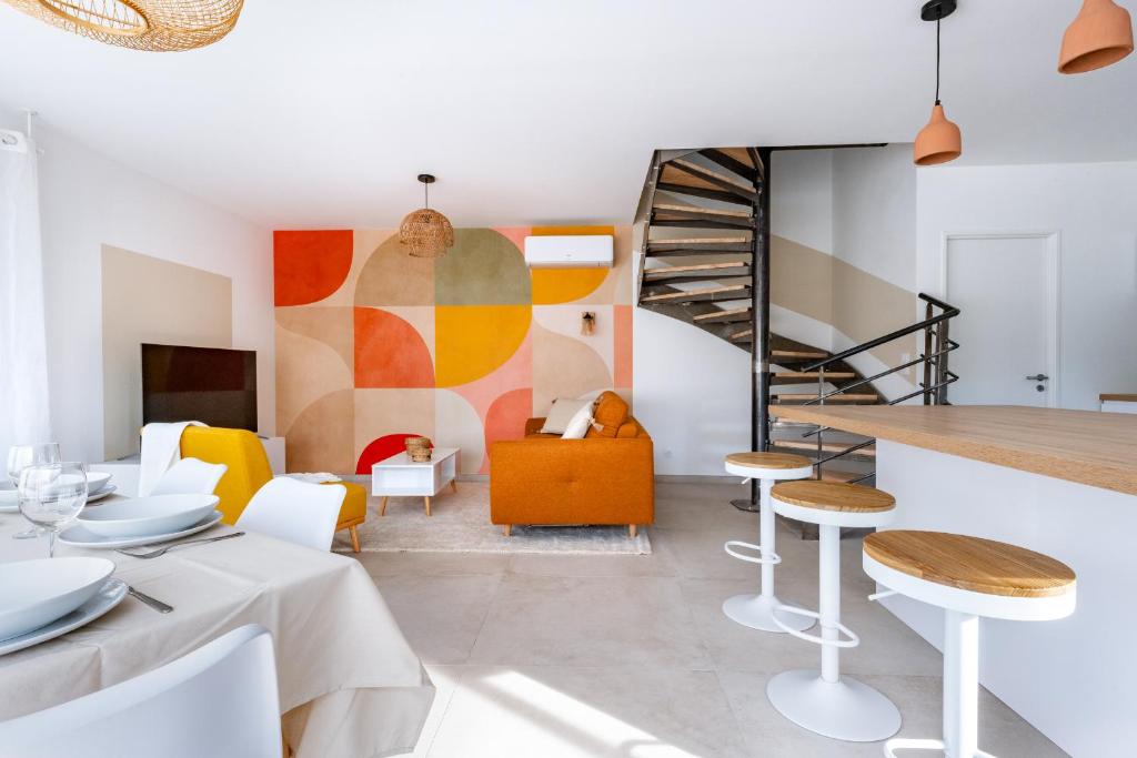 een woonkamer met een trap en een tafel en stoelen bij La Perle Villa neuve, proche gare, comédie, et tramway in Montpellier