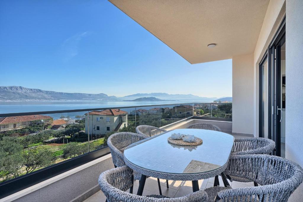 a table and chairs on a balcony with a view of the ocean at Mare‘s Place - Premium Seaview Apartment in Slatine