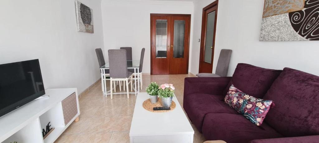 a living room with a purple couch and a tv at Sueños de Córdoba in Córdoba