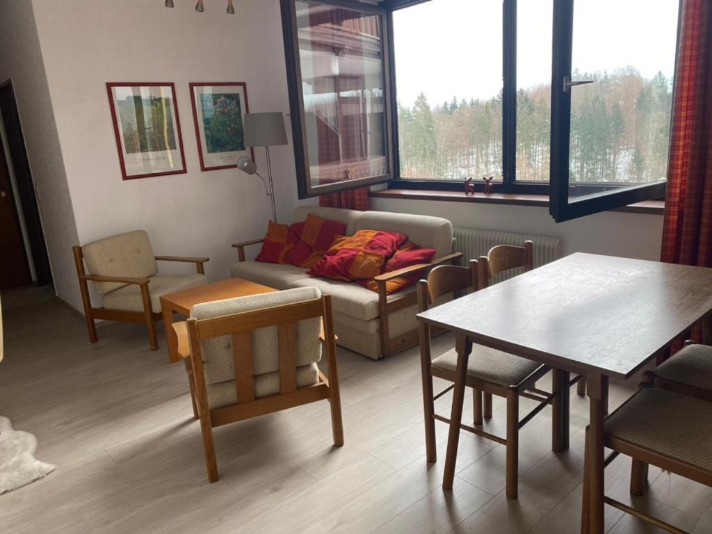a living room with a couch and a table and chairs at Dachstein Panorama-Lodge in Bad Goisern
