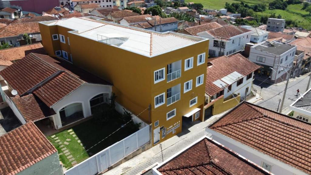 an overhead view of a yellow house with red roofs at Verissimu's Pousada in Paraisópolis
