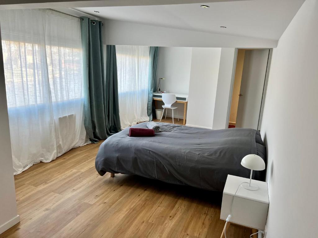 1 dormitorio con cama y escritorio. en Sur le Loing, en Moret-sur-Loing