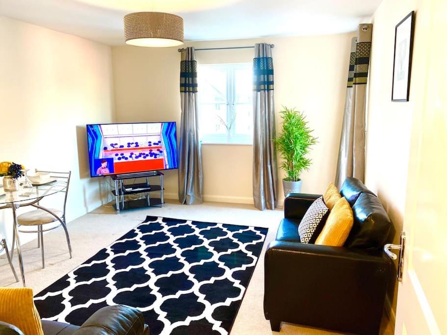 a living room with a couch and a tv at Amazing 2-Bed City Centre Apt with Parking in Spon End