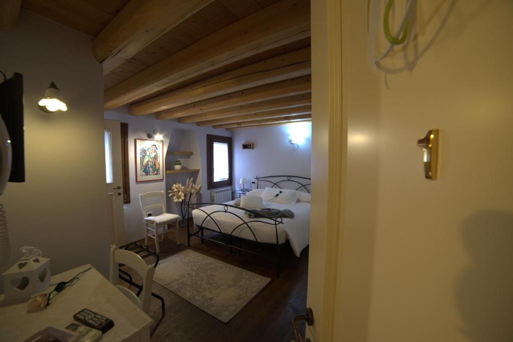 a bedroom with a bed and a table in a room at B&B Casa Perla in Chioggia