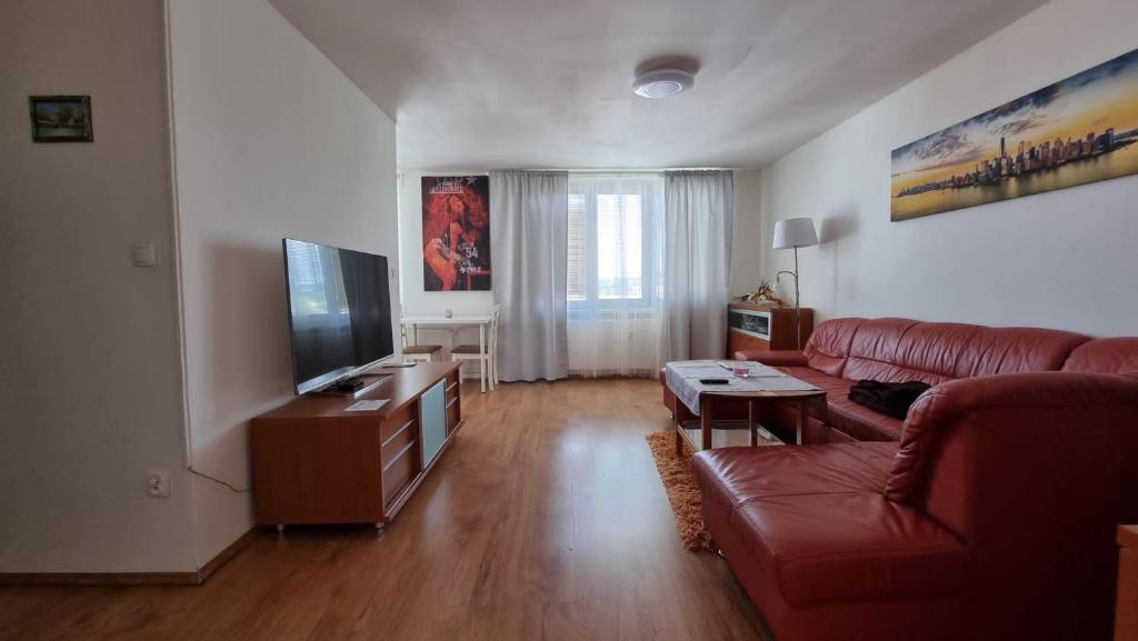 a living room with a red couch and a flat screen tv at Luxury apartment in beautiful small town in Nový Jičín