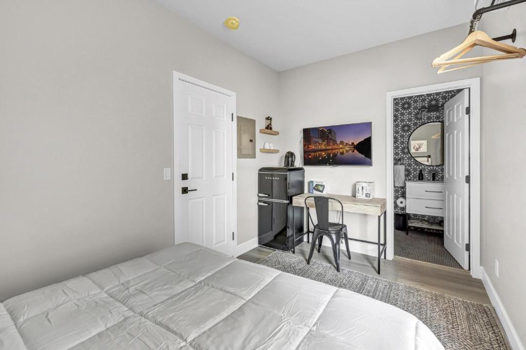 een witte slaapkamer met een bed en een tafel bij Single Bedroom - Queen Size. Heart of Downtown Vista in Vista