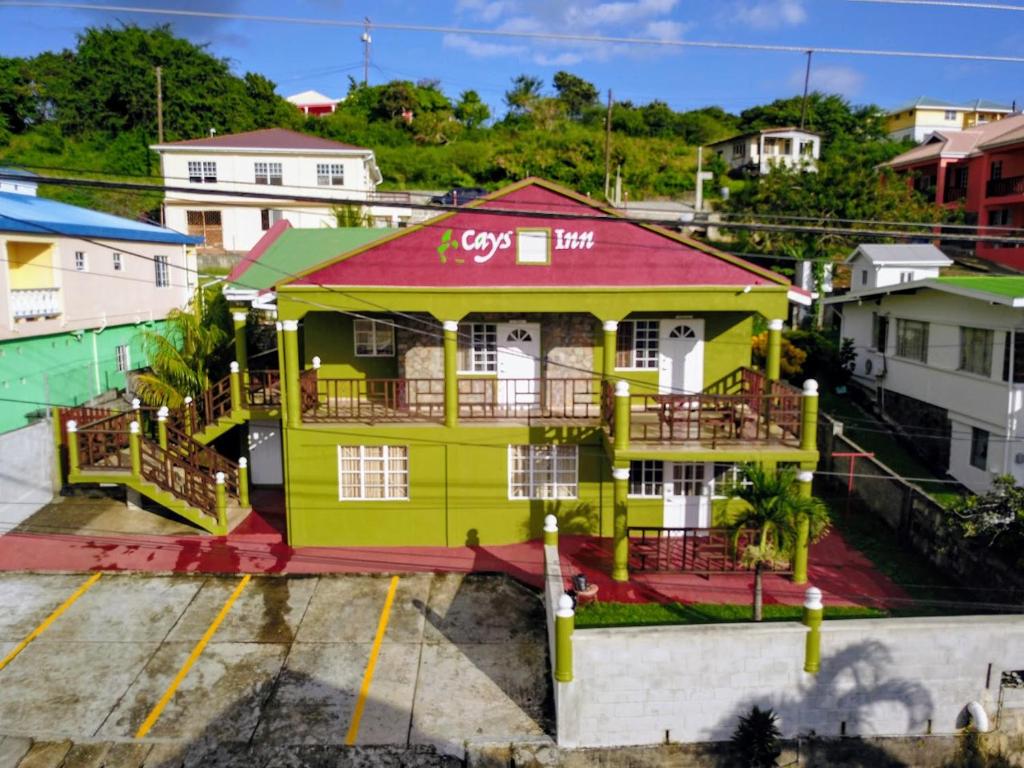 una casa amarilla con techo rojo en Cays Inn Apartments en Ribishi