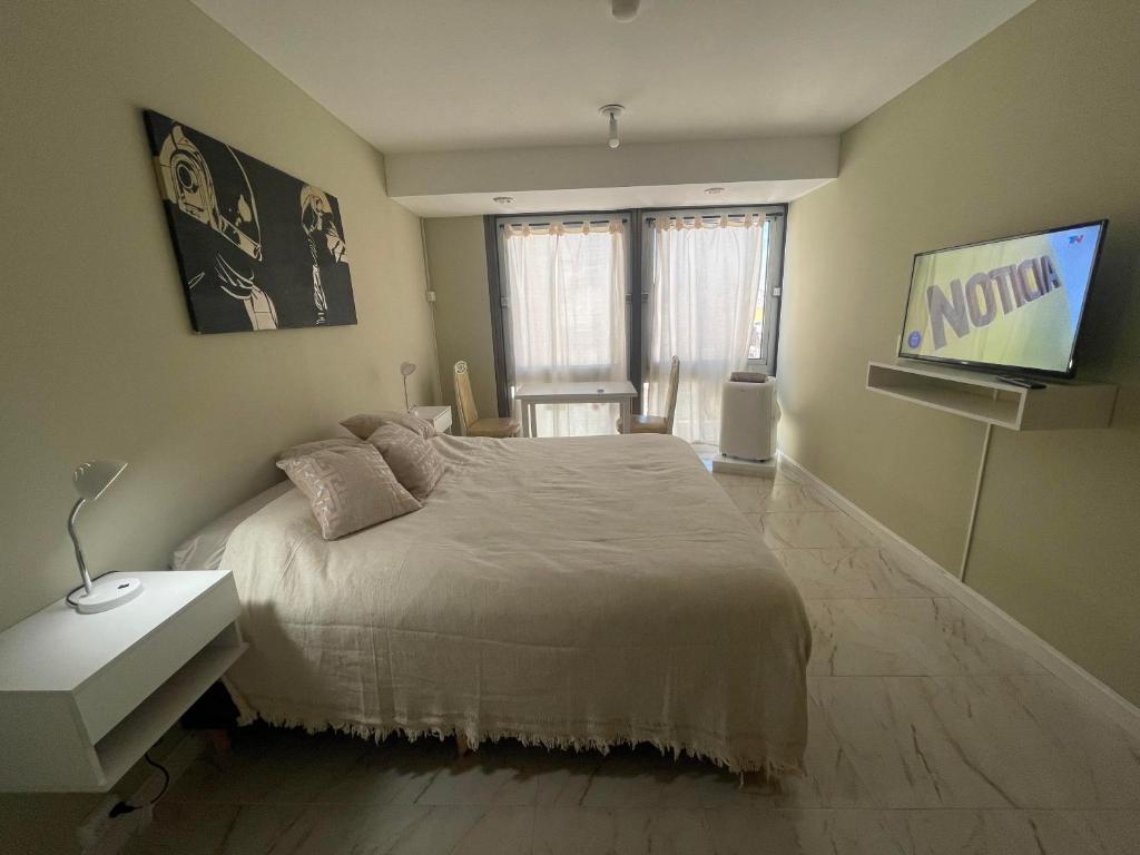 1 dormitorio con 1 cama y TV. en Hermoso departamento minimalista en Buenos Aires
