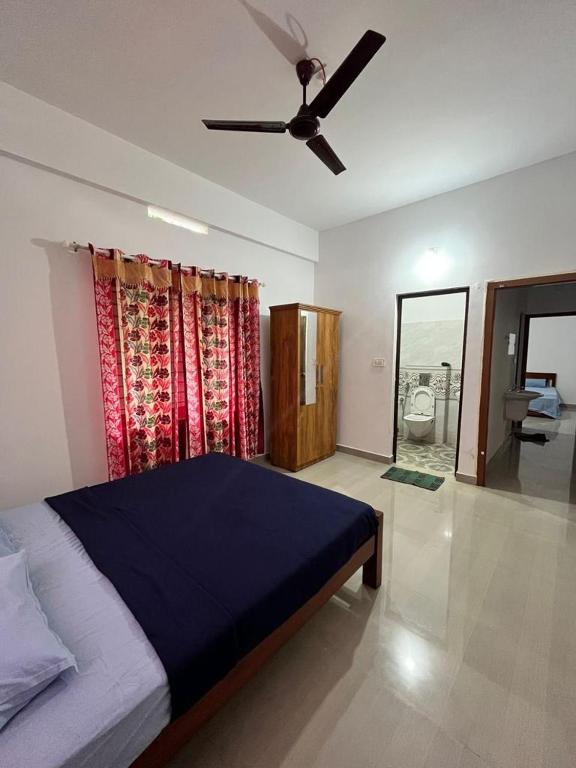 a bedroom with a bed and a ceiling fan at Wayanad Biriyomz Residency, Kalpatta, Low Cost Rooms and Deluxe Apartment in Kalpetta