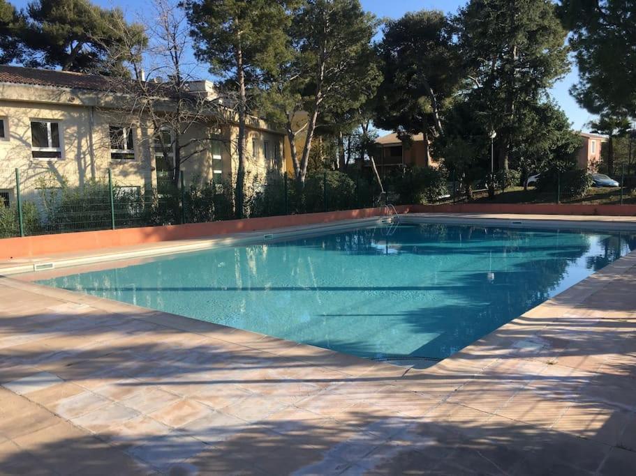 une piscine avec de l'eau bleue devant un immeuble dans l'établissement LA CALMERAIE, à Villeneuve-Loubet