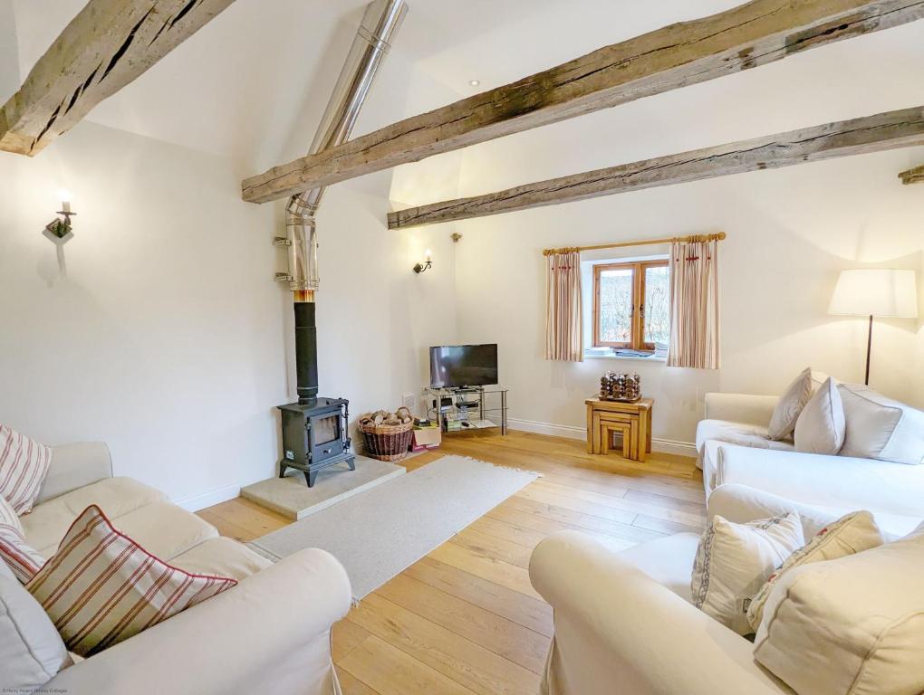 a living room with white furniture and a wood stove at Old Root House, Lavant in Chichester