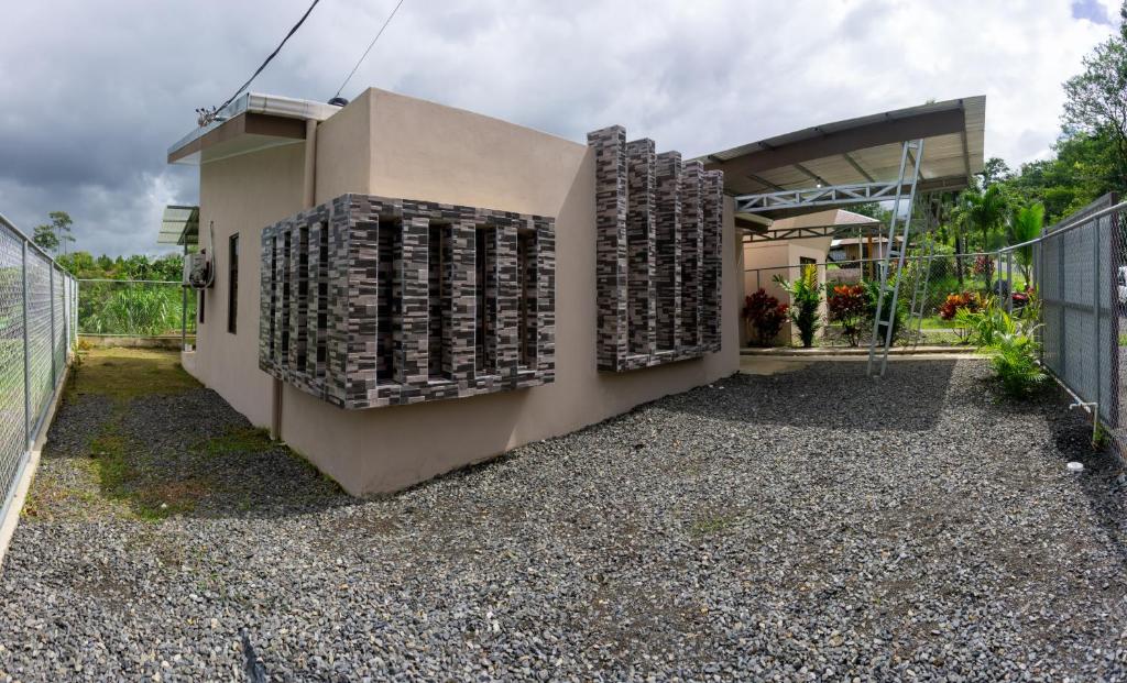 Una casa con un montón de ladrillos a un lado. en Wild Arenal Village, en Fortuna