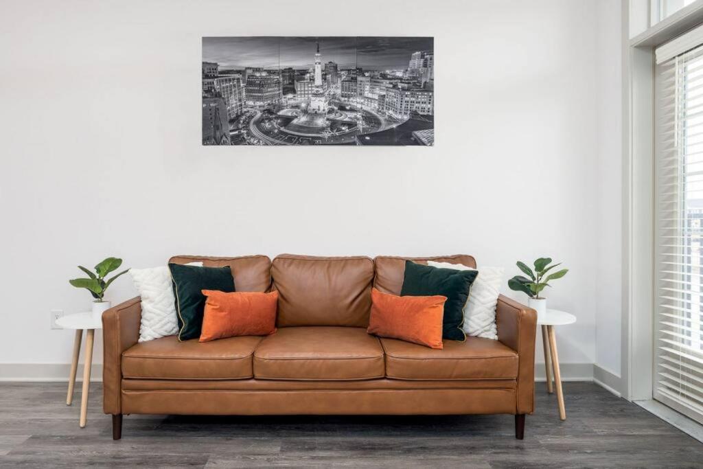 um sofá castanho numa sala de estar com um quadro na parede em Lovely Private bedroom - Shared em Whitestown