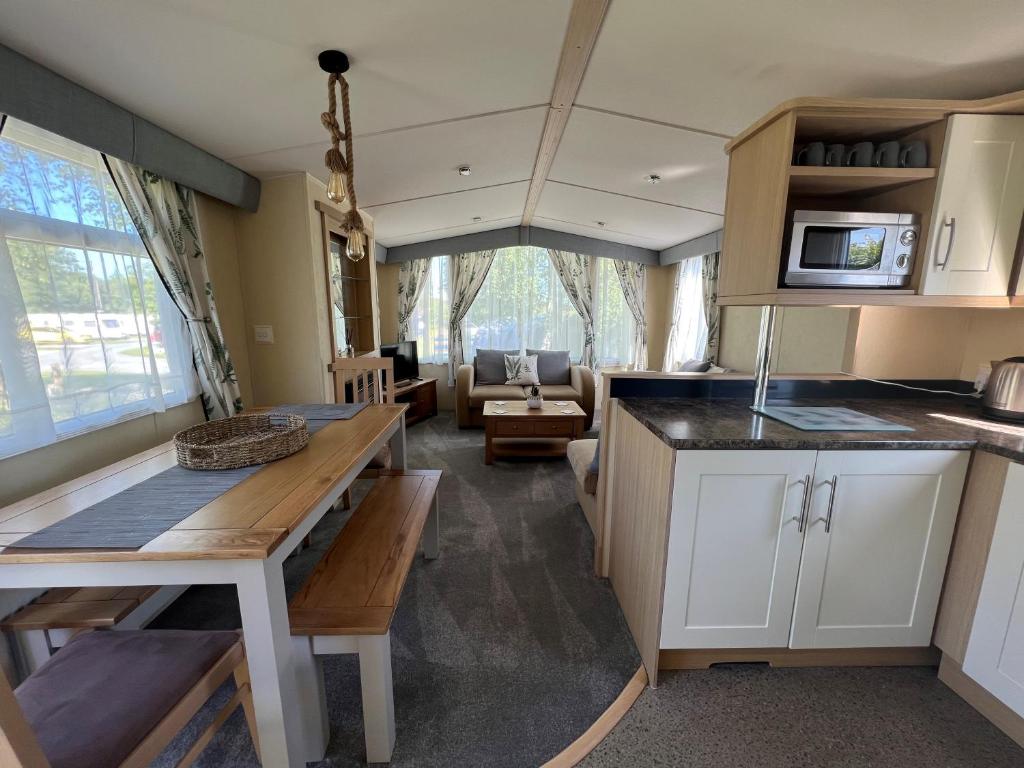 a kitchen and living room in a tiny house at Polladras Holiday Park in Helston