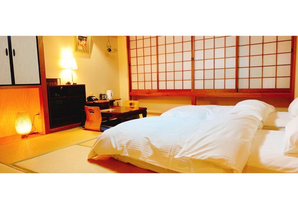 - une chambre avec 2 lits blancs et une table dans l'établissement Nara Ryokan - Vacation STAY 49570v, à Nara