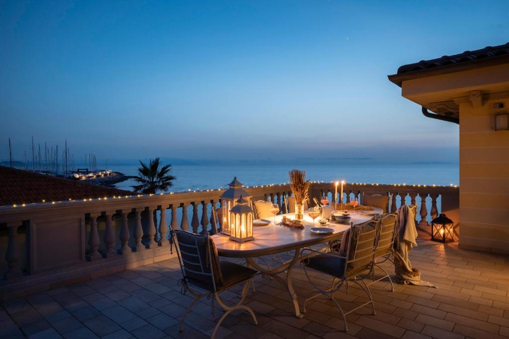 - une table à manger sur un balcon avec vue sur l'océan dans l'établissement Villa Teti, à San Vincenzo