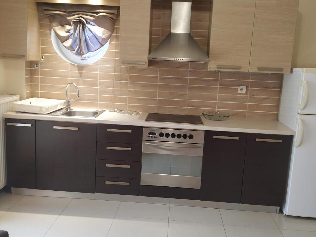 uma cozinha com um fogão, um lavatório e um frigorífico em Family House em Agios Nikolaos