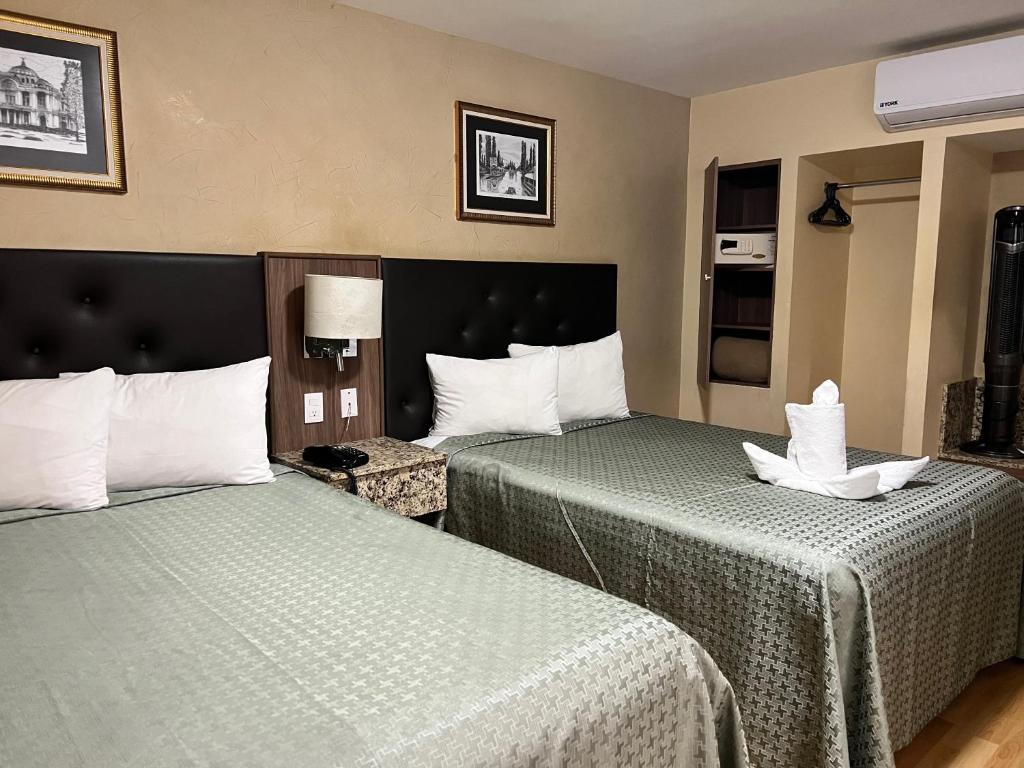 Habitación de hotel con 2 camas con sábanas verdes en Hotel Castropol en Ciudad de México