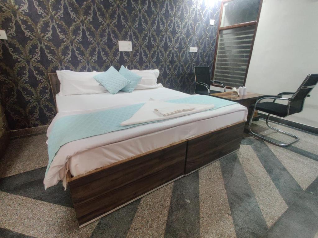 a bedroom with a large bed with a desk and a chair at Dev Residency in Gurgaon
