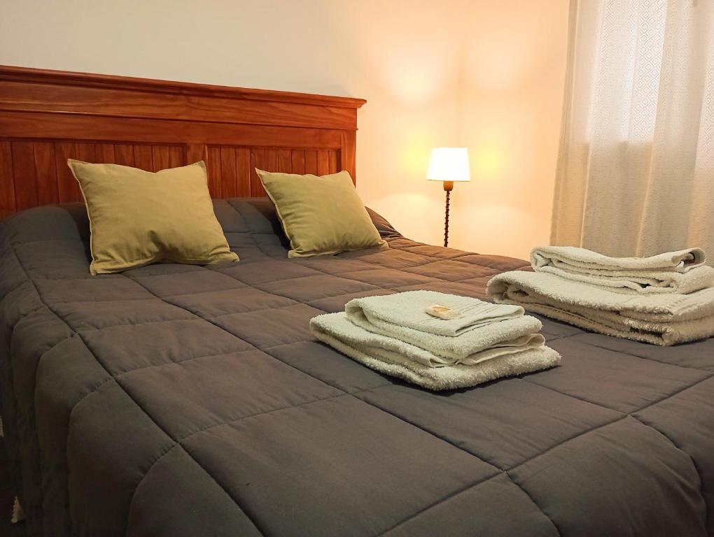 een slaapkamer met een bed met handdoeken erop bij La Casita in Esquel