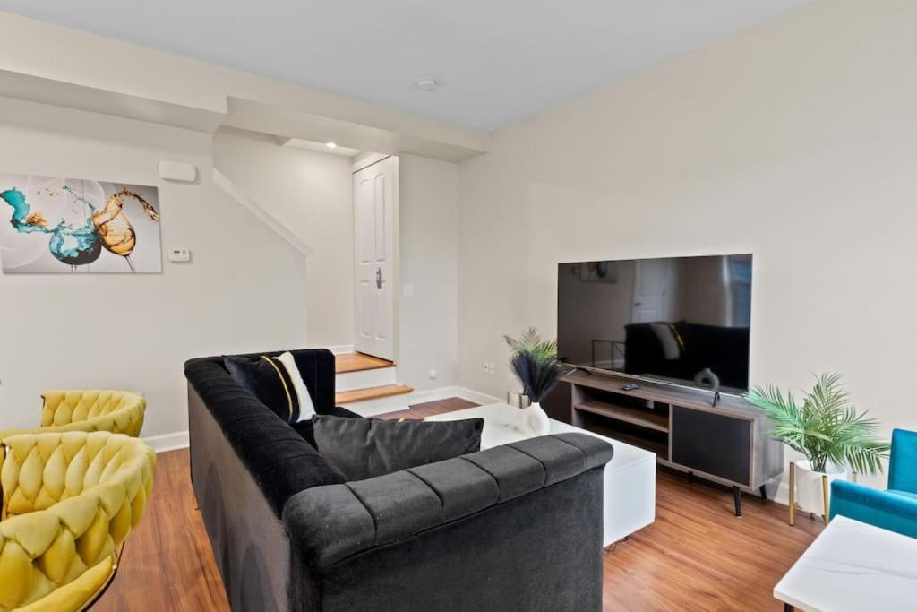 ein Wohnzimmer mit einem Sofa und einem TV in der Unterkunft Your Cozy One Bedroom Midtown in Detroit