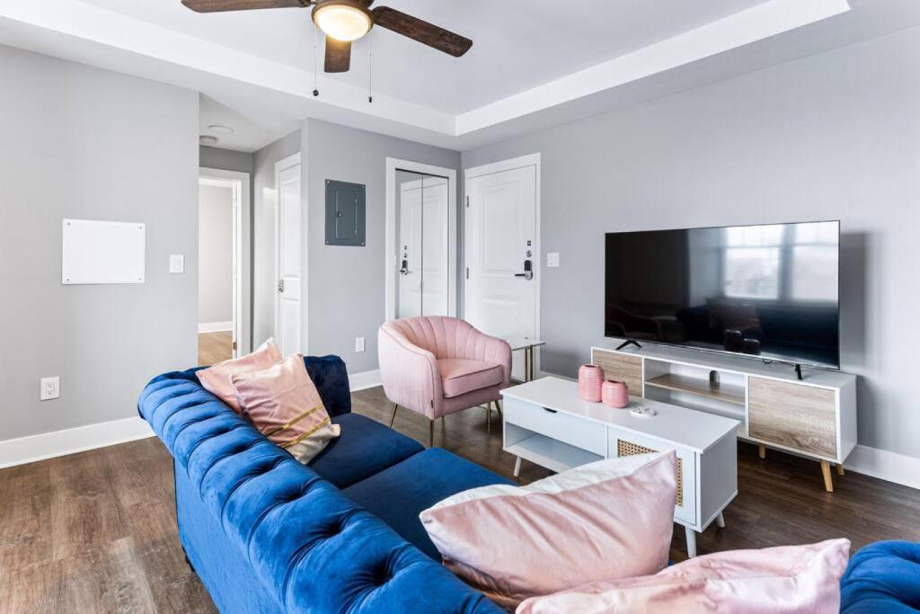 sala de estar con sofá azul y TV en Your Cozy One Bedroom Midtown, en Detroit