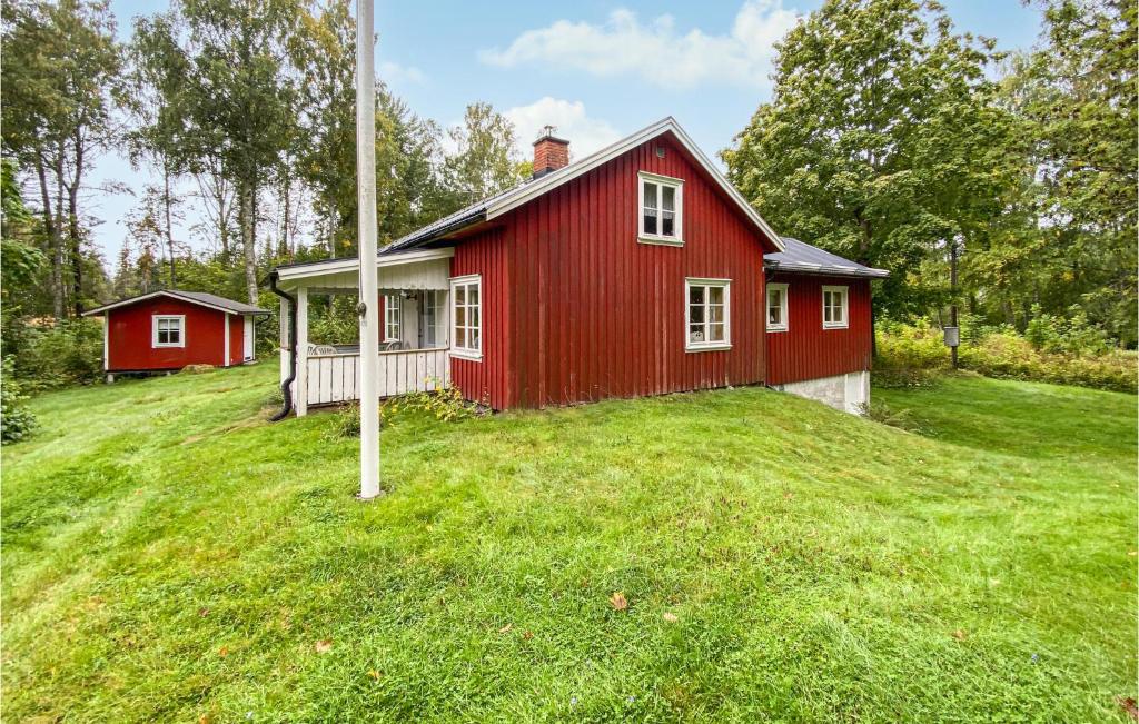 ein rotes Haus auf einem grasbewachsenen Hügel mit einer Stange in der Unterkunft 3 Bedroom Cozy Home In Lngserud in Rullan