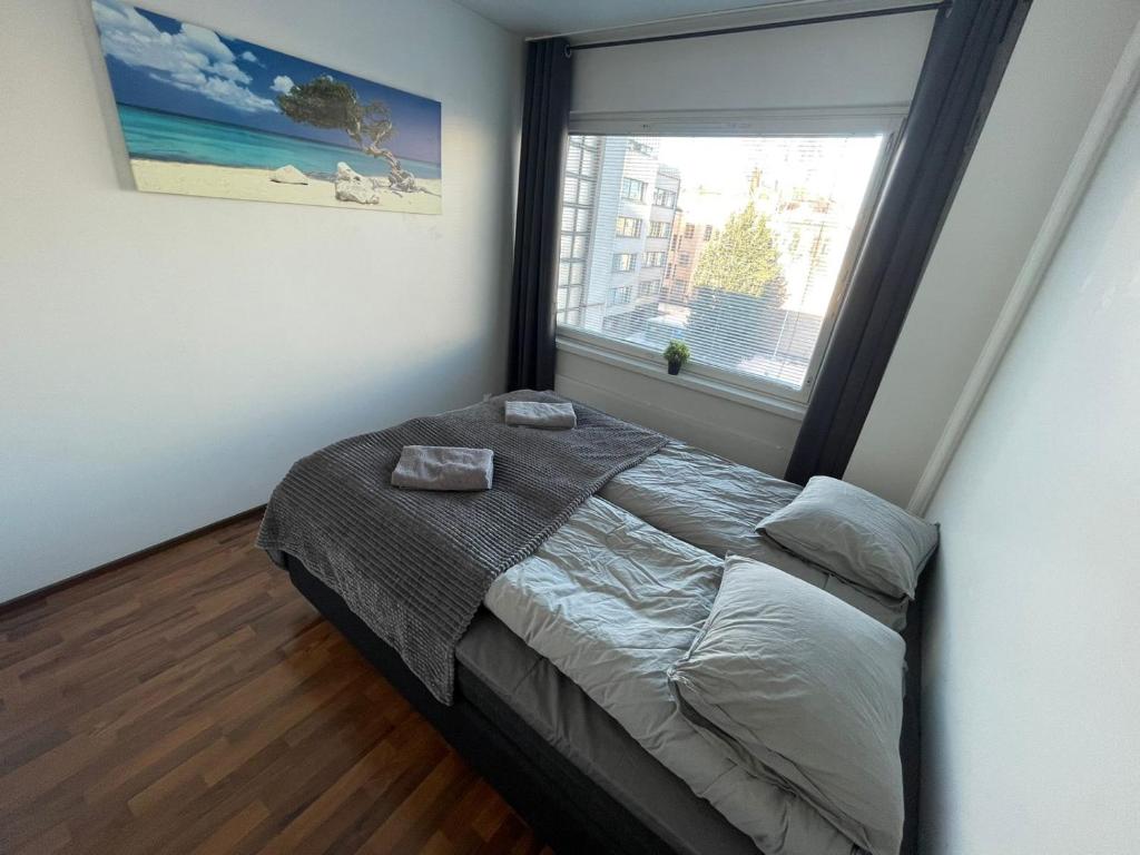 ein Schlafzimmer mit einem Bett und einem großen Fenster in der Unterkunft Oulu city center 4-room apartment Parking in Oulu