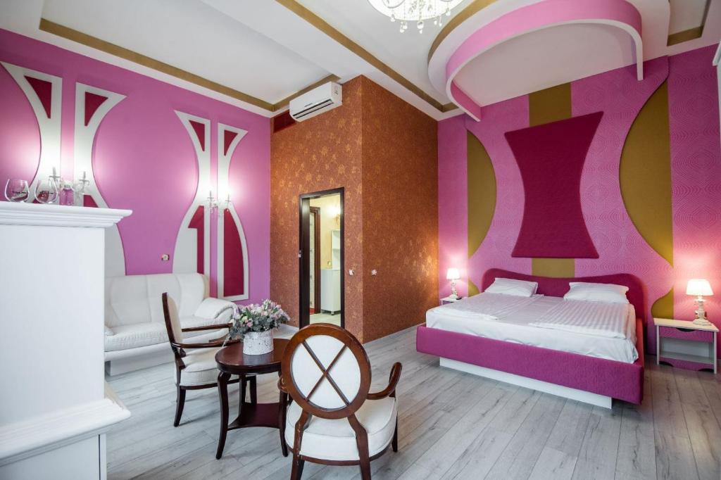 sypialnia z łóżkiem, stołem i krzesłami w obiekcie Apartament La Teatru Boudoir w mieście Oradea