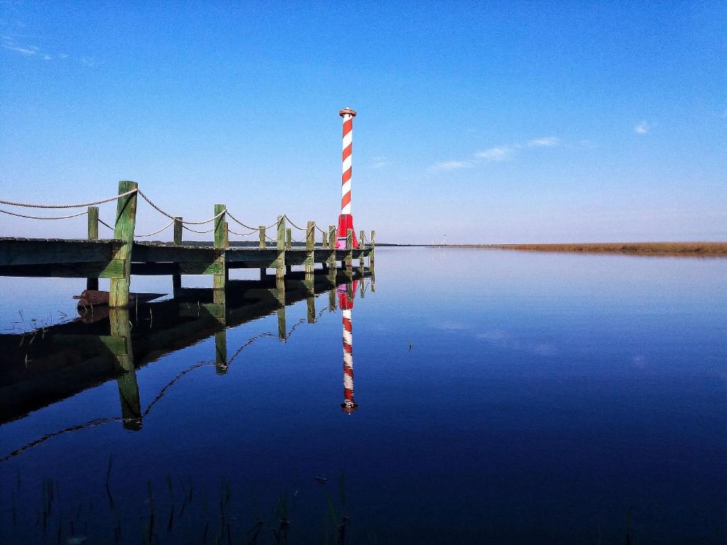 a dock with a pole in the middle of the water at Lagoa Country Club in Cidreira