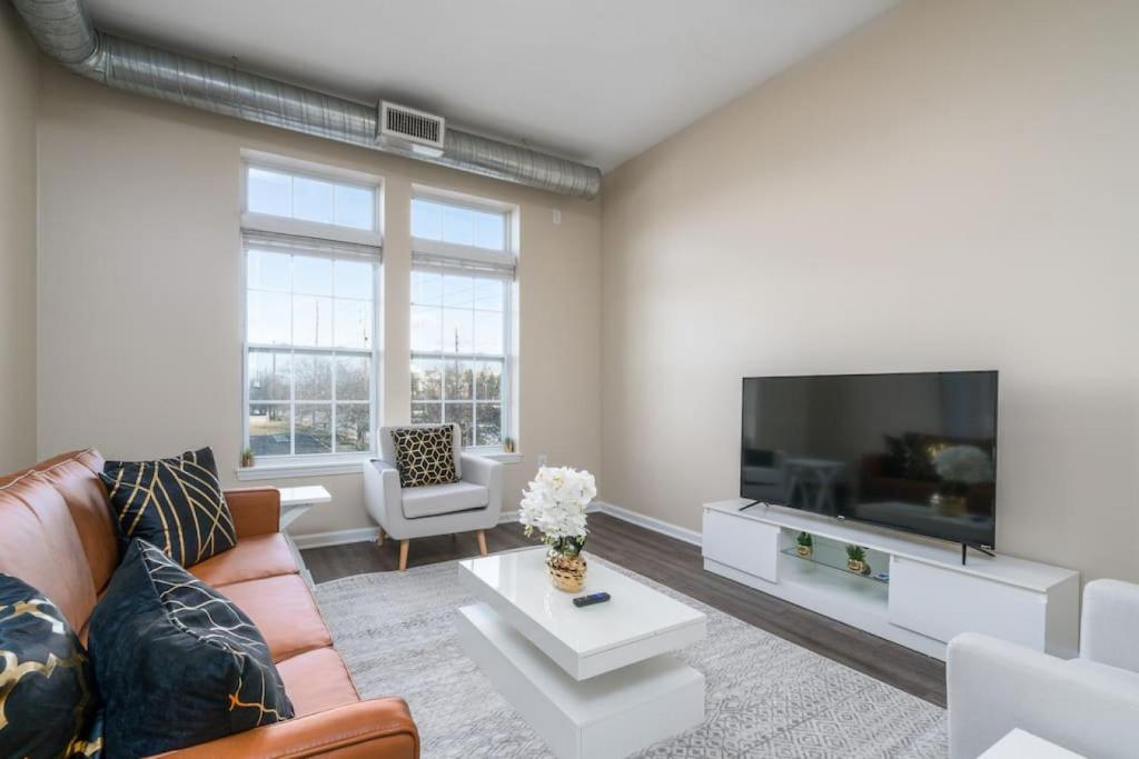 een woonkamer met een bank en een flatscreen-tv bij Private Bed Downtown INDY - Shared in Indianapolis