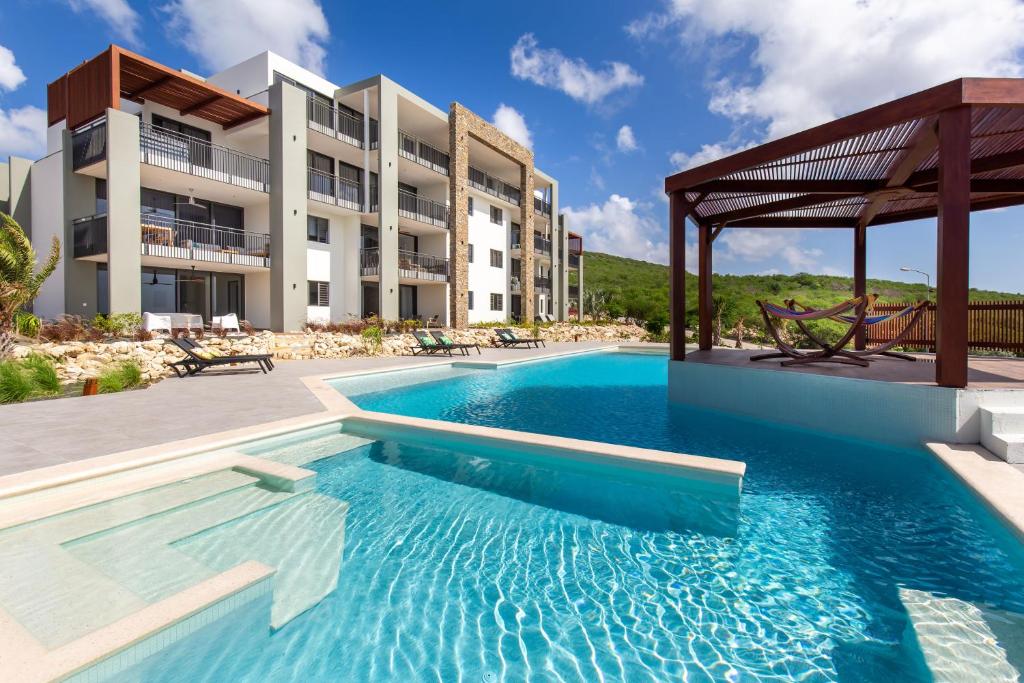 a swimming pool in front of a building at Coral Estate Ocean View Apartments in Willemstad