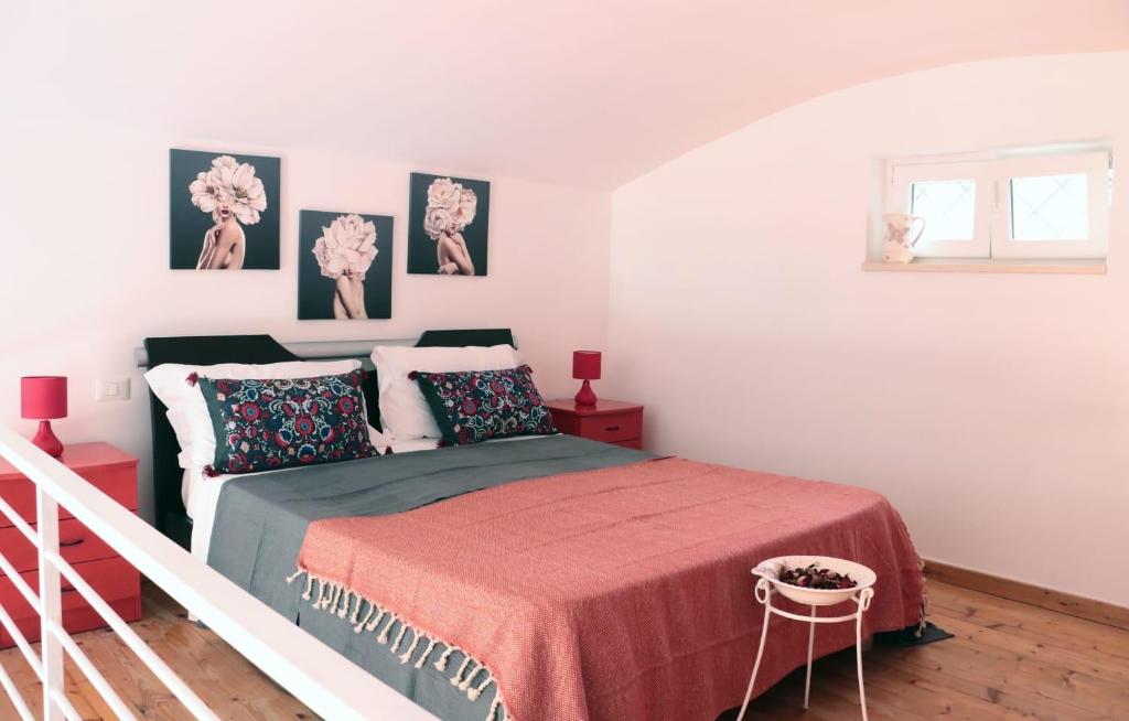 um quarto branco com uma cama com um cobertor vermelho em sea home em Bacoli