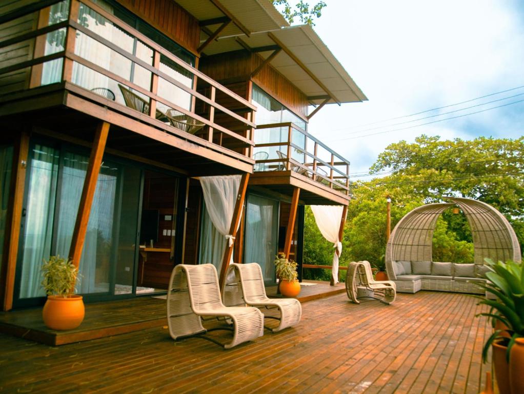 ein Haus mit einer Terrasse mit Stühlen und einem Balkon in der Unterkunft Ilha do Mel Lodges in Ilha do Mel