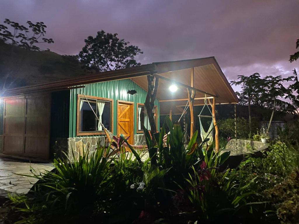 Chorotega Cabina في مونتيفيردي كوستاريكا: منزل به واجهة خضراء في الليل