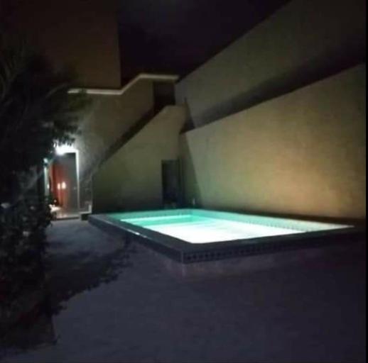 ein Schwimmbad in einem Gebäude in der Nacht in der Unterkunft RIAD AMINE in Taroudant