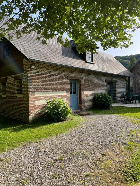 une vieille maison en briques avec une porte bleue dans l'établissement Gîte du « Lavoir » à 2 pas de la mer, à Saint-Martin-le-Gaillard