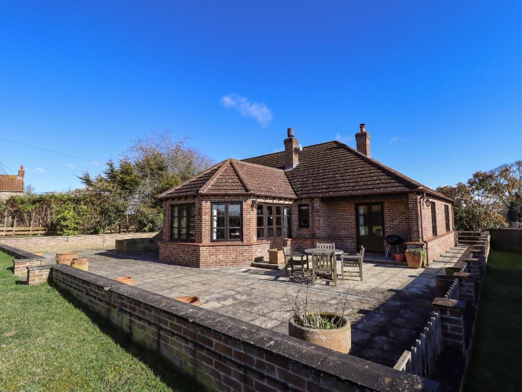 a brick house with a patio in front of it at The Paddock in Market Rasen