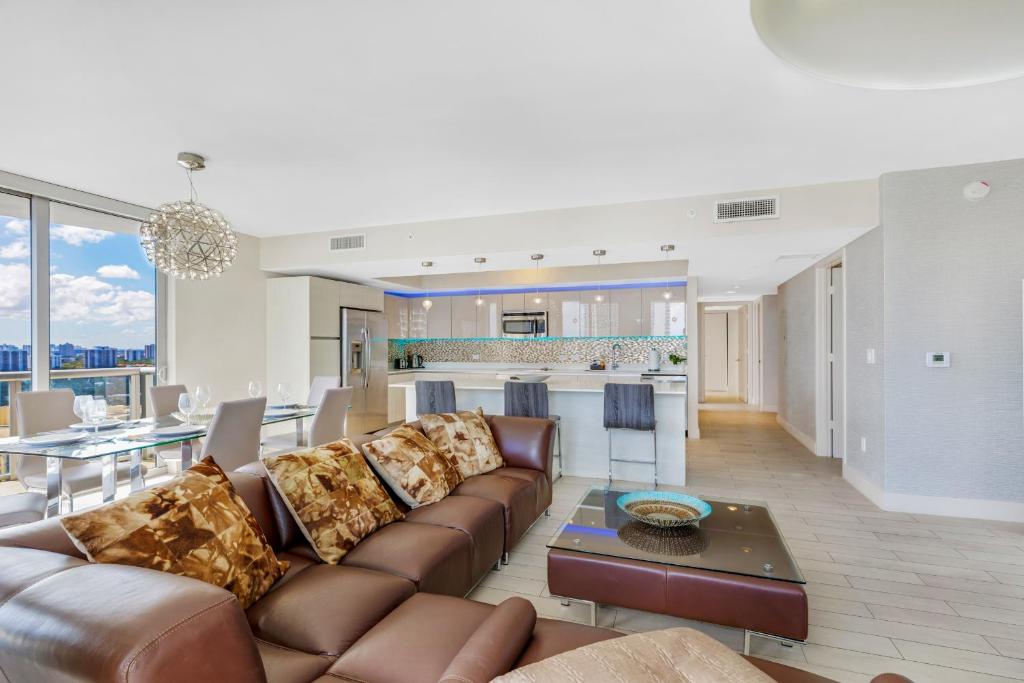 a living room and kitchen with a couch and a table at Beachwalk Resort #2301 - MODERN RESORT 3BDR and 3BA - BALCONY, GYM, AMAZING POOL in Hallandale Beach