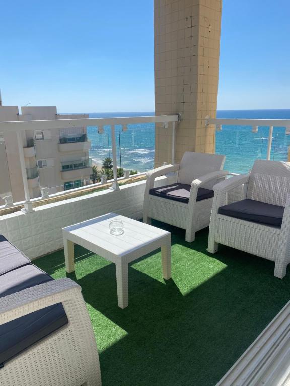 a balcony with chairs and a table and a view of the ocean at APARTMENT OSCAR BEACH 2 in Bat Yam