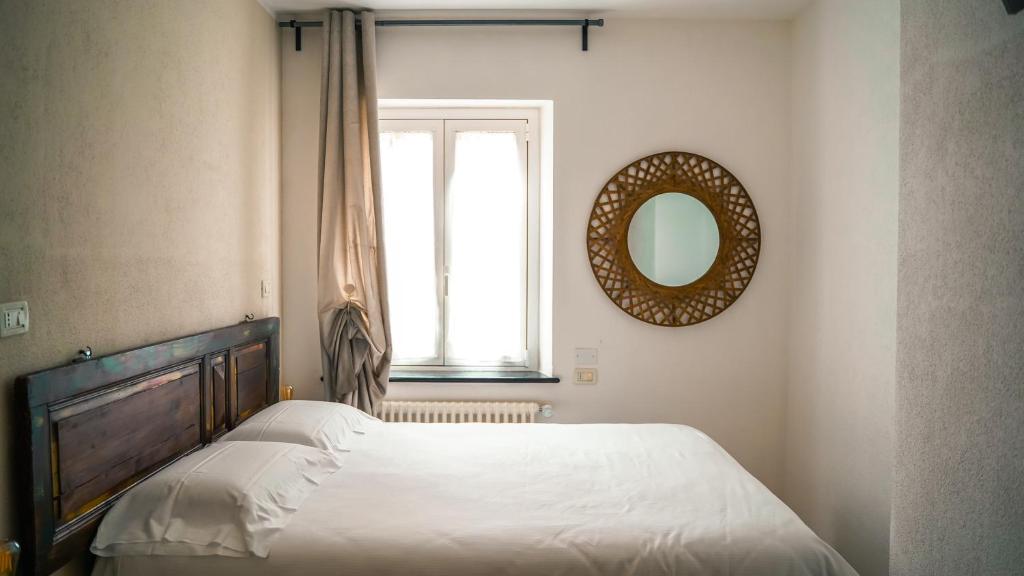 a bedroom with a bed with a mirror and a window at Piccolo Borgo in Chiavari