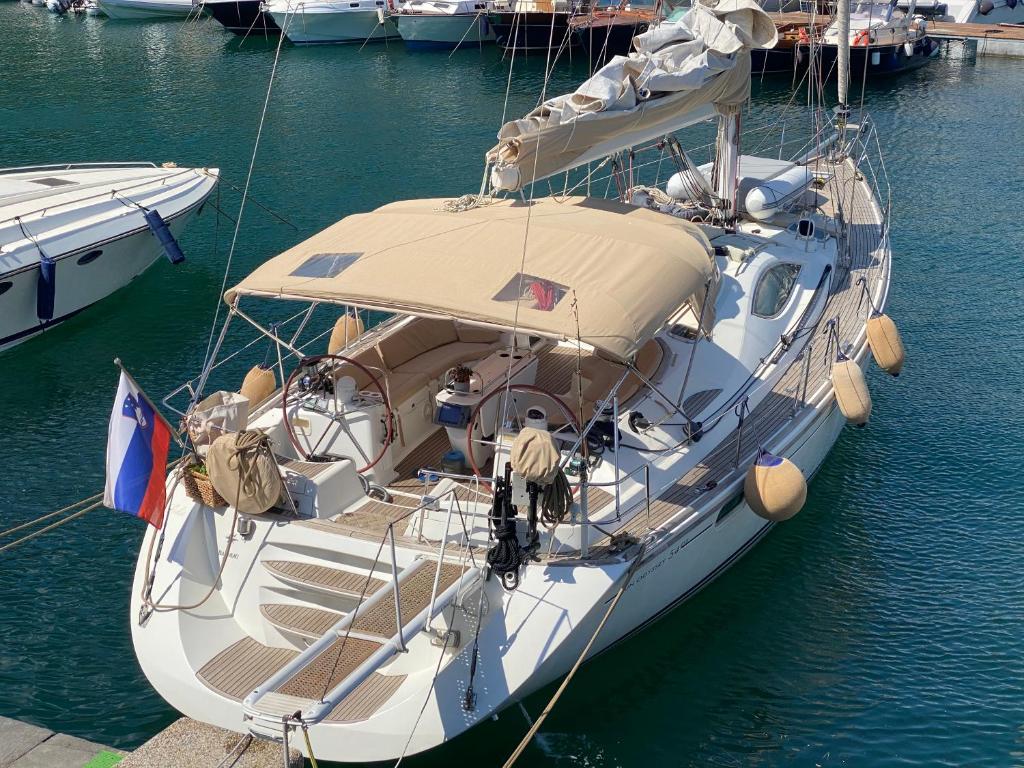 a white boat is docked in the water at Jeanneau Sun Odyssey 54 DS LULU’ in Nydri