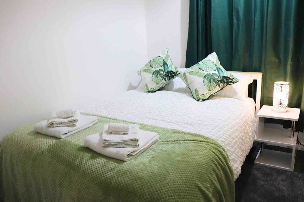 1 dormitorio con 1 cama con toallas en Unique 3 Bedroom House FREE WiFI & Parking en Knowsthorpe