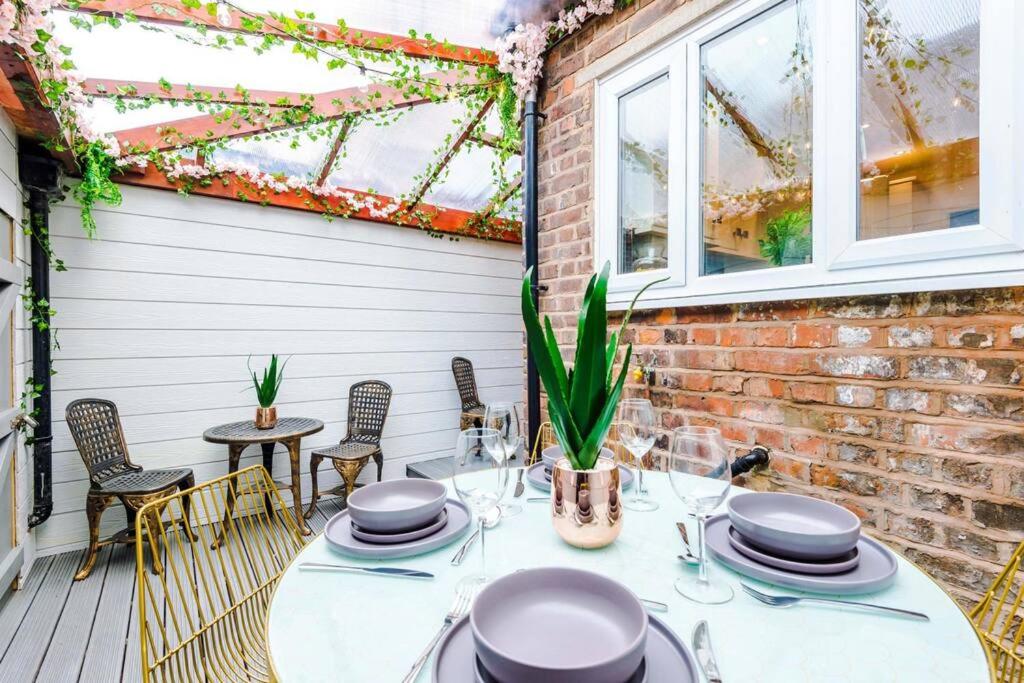 a patio with a table and chairs and windows at Rest&Recharge at a Luxury Retreat in Manchester - Sleeps 11, 5 Bedrooms, 3 Bathrooms, Free Parking in Manchester