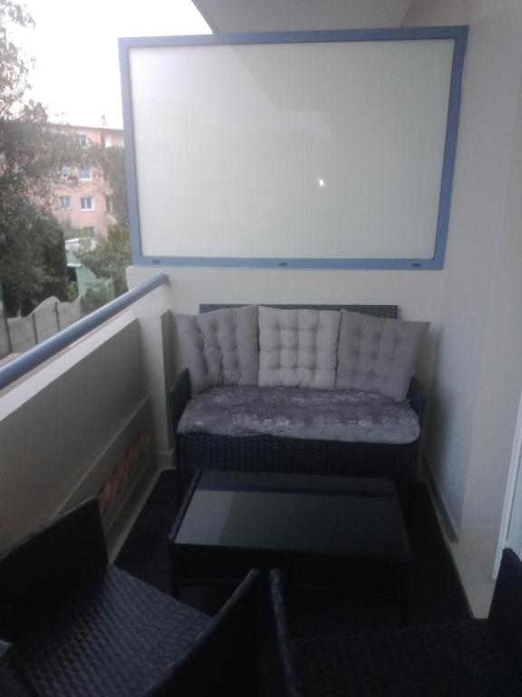 - un canapé dans une pièce avec fenêtre dans l'établissement jasmin, à Saint-Raphaël