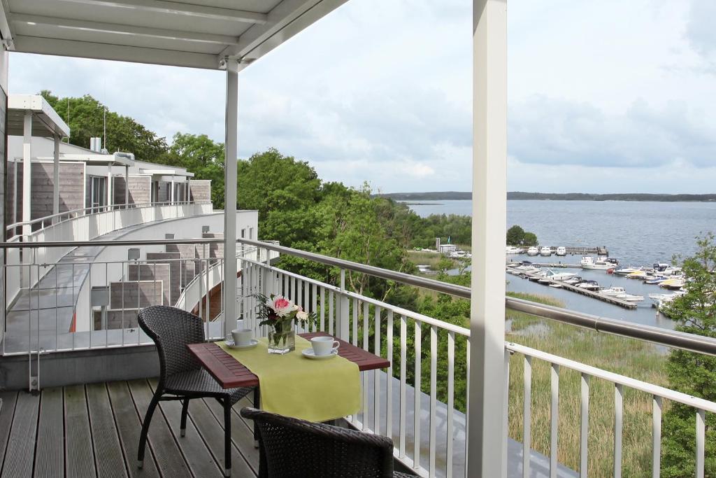 einen Balkon mit einem Tisch und Stühlen sowie Blick auf das Wasser in der Unterkunft Seehotel Fleesensee in Göhren-Lebbin
