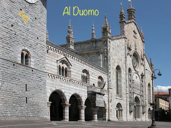 コモにあるAl Duomo guest houseの時計付きの大きなレンガ造りの建物